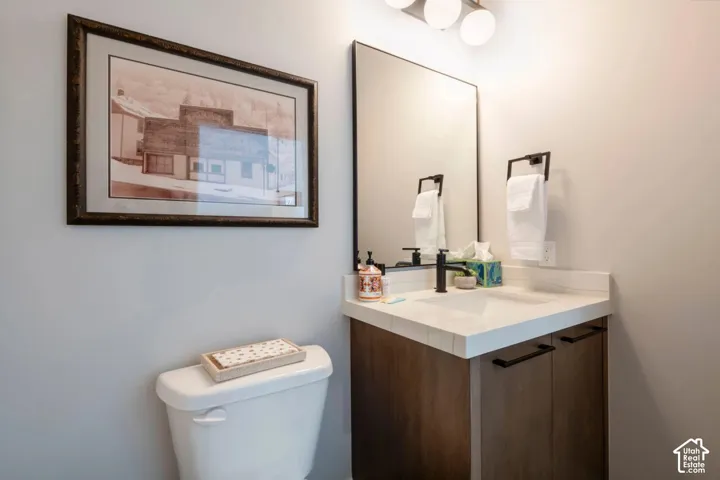Modern vanity with wood-finish cabinetry, white countertop, and integrated sink