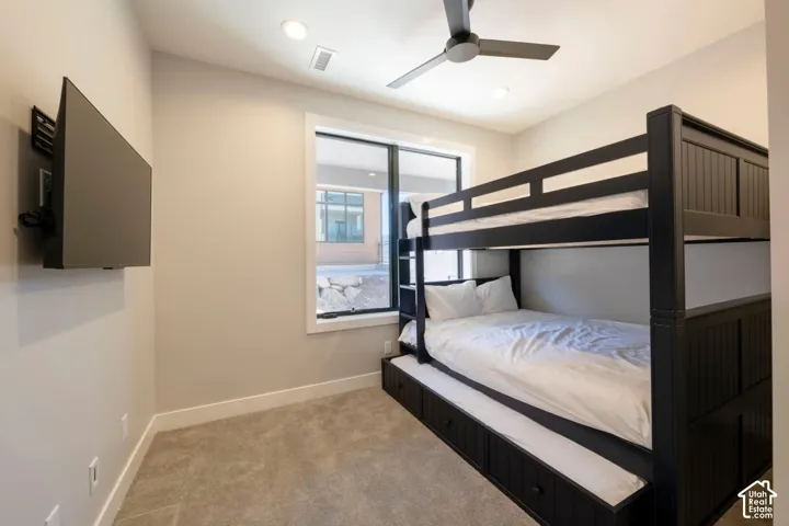 Carpeted room with a ceiling fan, recessed lighting, and a large window