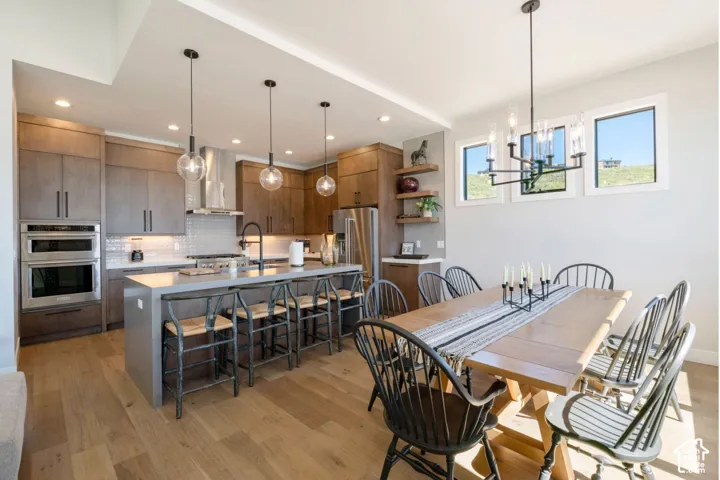 Open-concept kitchen and dining area featuring wood-finish flooring, recessed lighting, and a kitchen island with pendant lighting