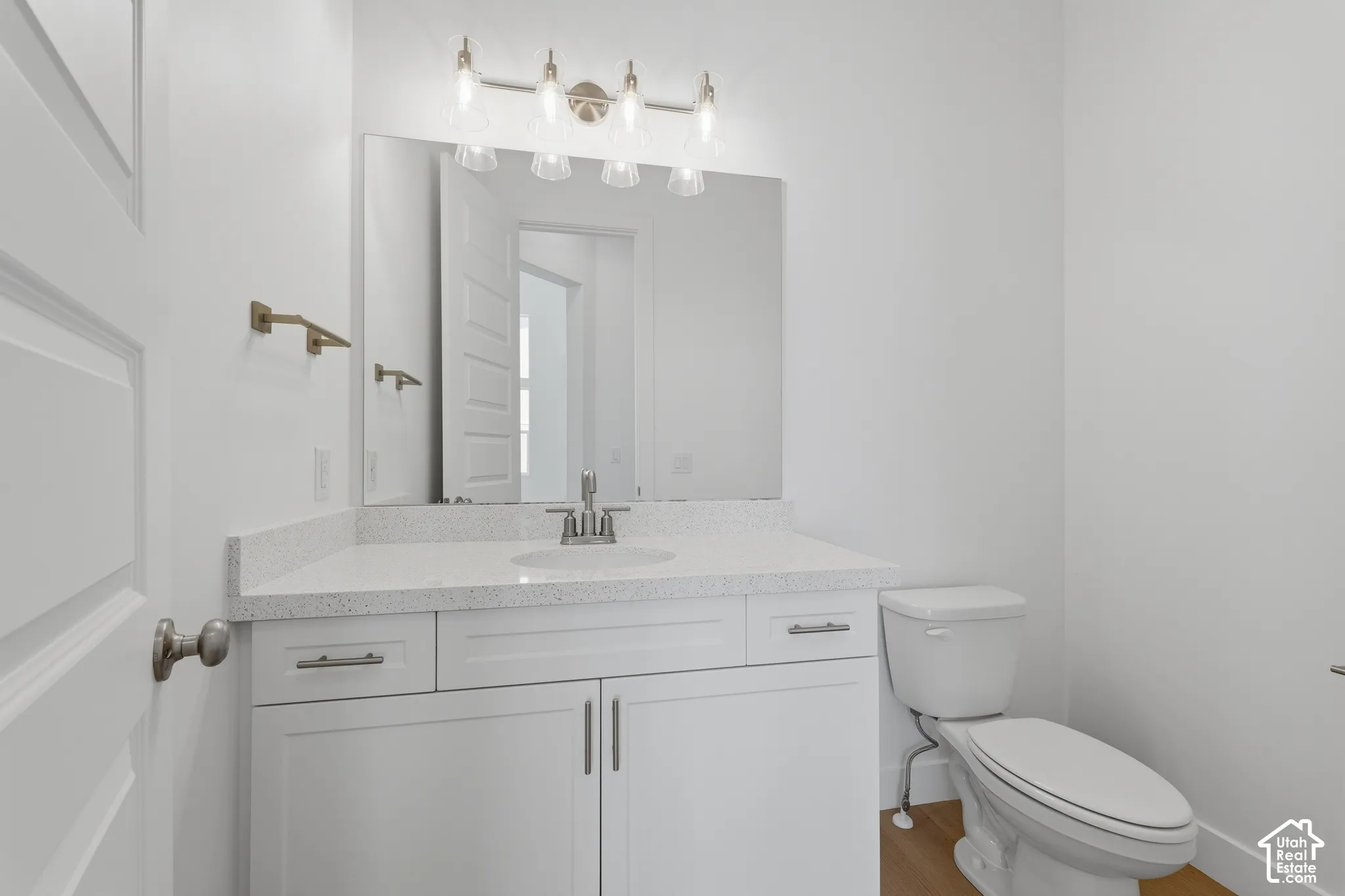 White vanity with integrated sink, speckled countertop, and brushed nickel hardware