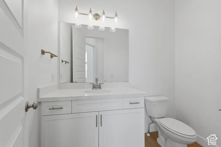 White vanity with integrated sink, speckled countertop, and brushed nickel hardware