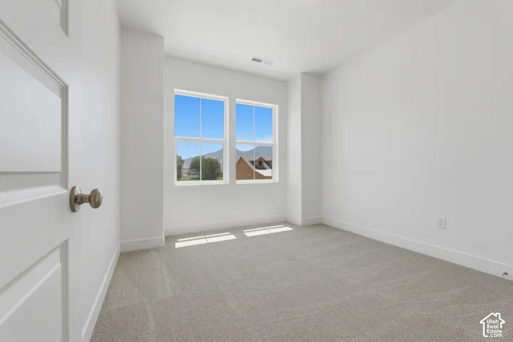 Bright room with two double-hung windows, light gray carpet, and white walls