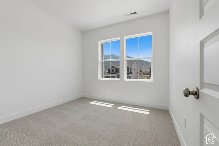 Bright interior with dual pane windows, neutral carpeting, and white painted walls