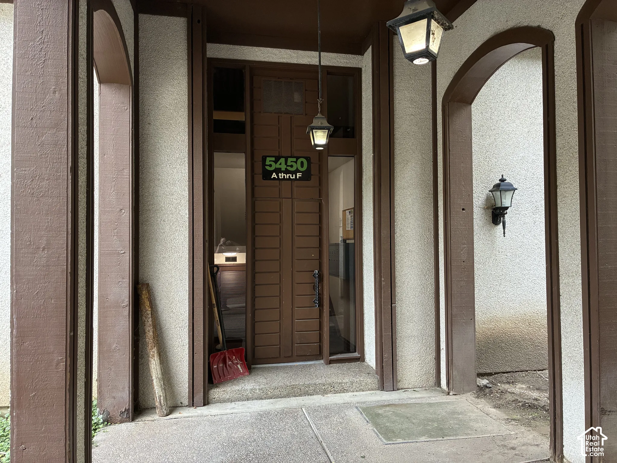 Entry with a wood-paneled door, flanking sidelight windows, and an overhead transom