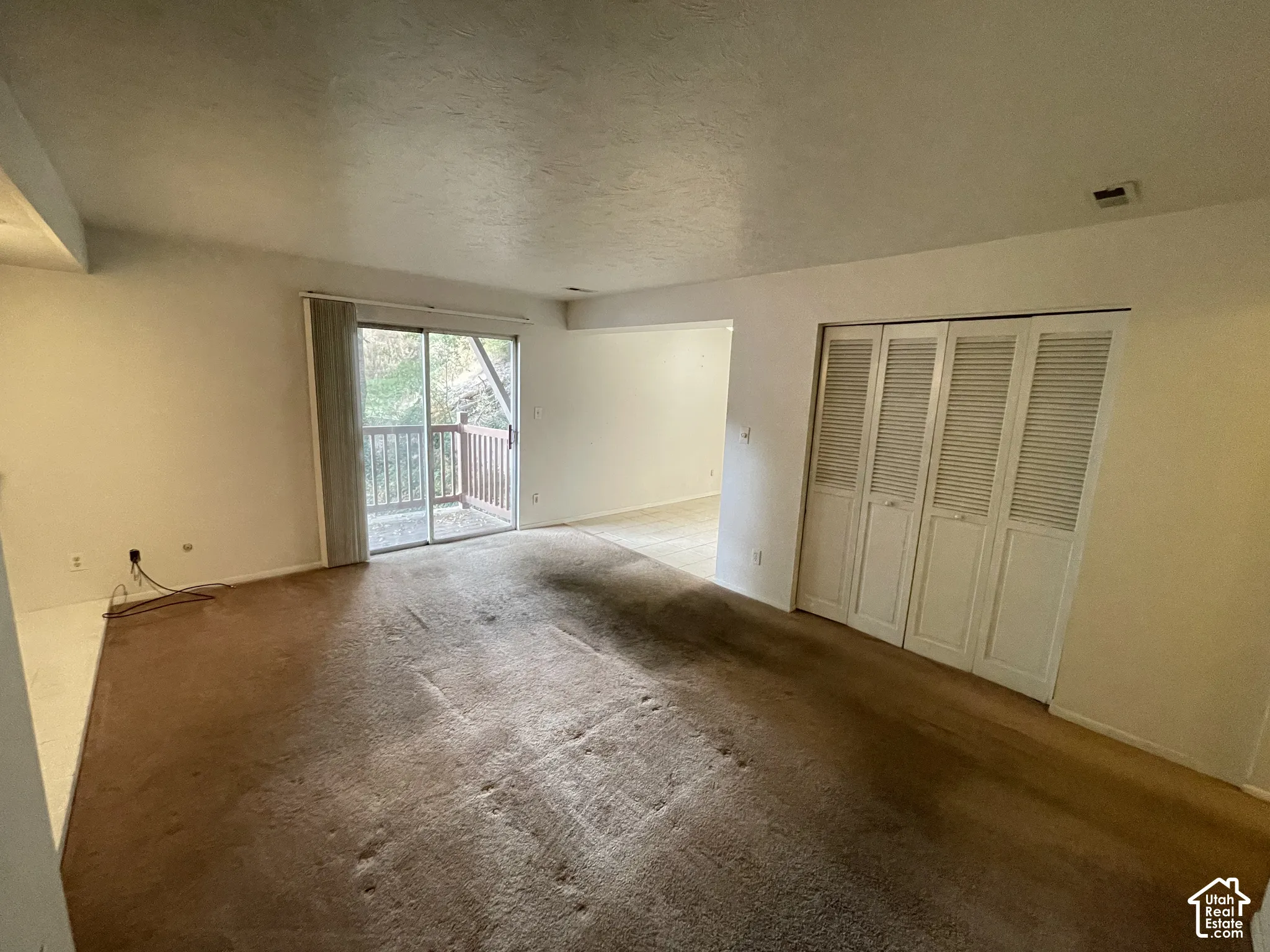 Sliding glass door leading to a private outdoor balcony with wood railing