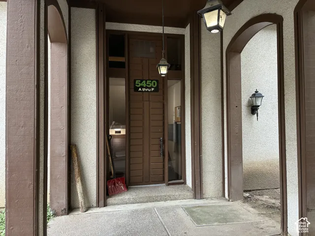 Entry with a wood-paneled door, flanking sidelight windows, and an overhead transom