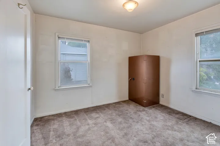 Neutral wall finishes, dual windows, and ceiling-mounted lighting fixture