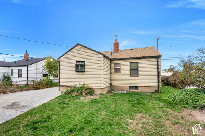 Manicured lawn with a concrete driveway and vinyl siding