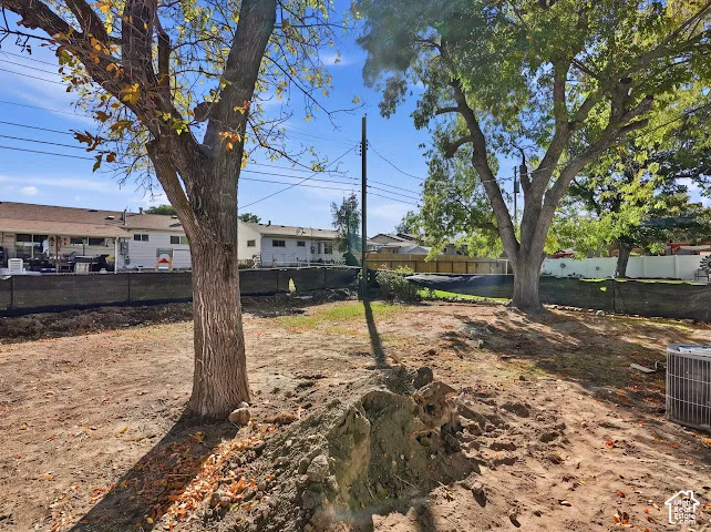 Expansive backyard featuring mature trees, a perimeter privacy fence, and a dedicated exterior HVAC unit