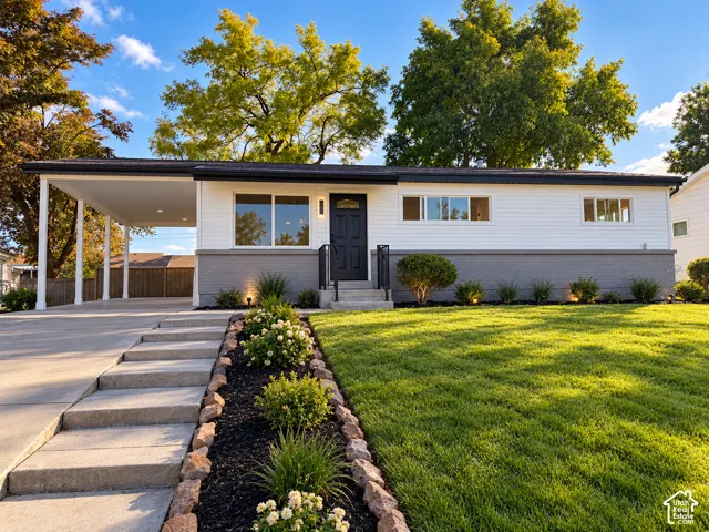 Modern facade featuring white siding with a contrasting gray brick foundation