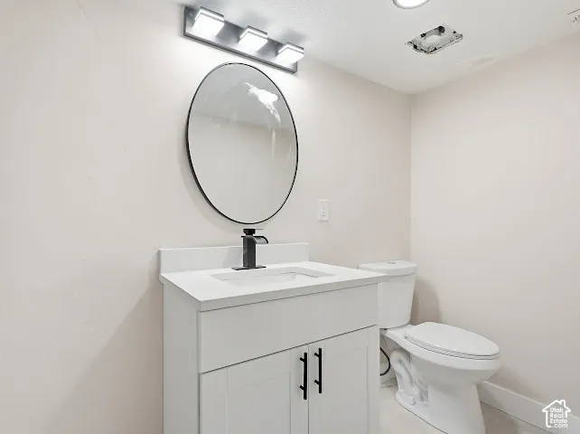 Modern vanity featuring a white cabinet, quartz countertop, integrated rectangular sink, matte black faucet, and a round wall-mounted mirror