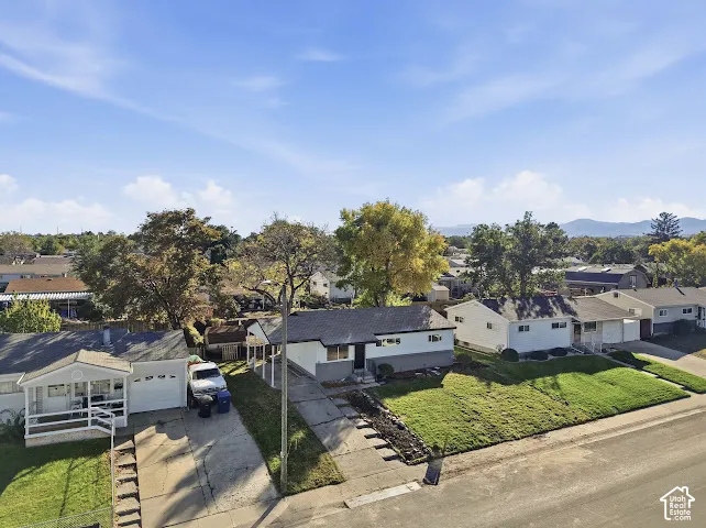 Single-story residence featuring a shingled roof, concrete driveway, and front lawn area