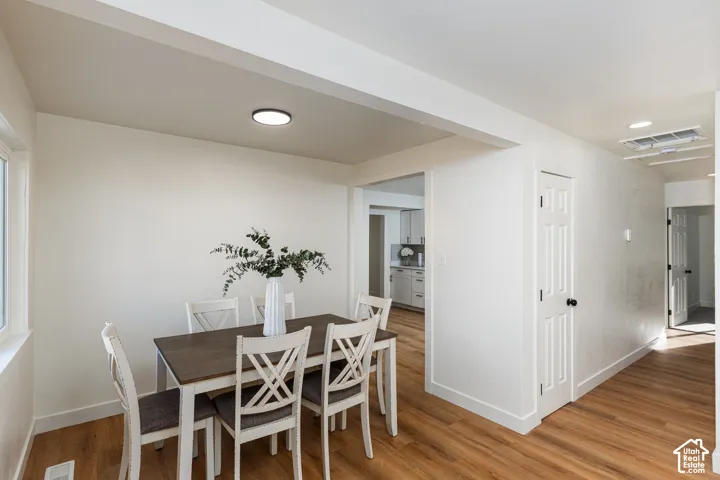 Expansive interior with wood-finish flooring, white walls, and a recessed ceiling light