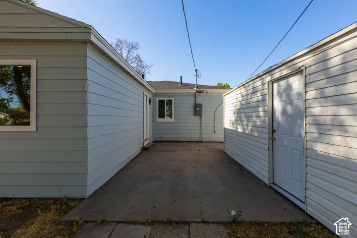 Concrete patio area framed by two structures with horizontal siding