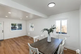 Recessed lighting, wood-finish flooring, white trim, multiple windows, and a ceiling-mounted light fixture