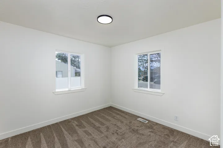 Clean interior with carpeted flooring, white walls, and a contemporary ceiling light fixture