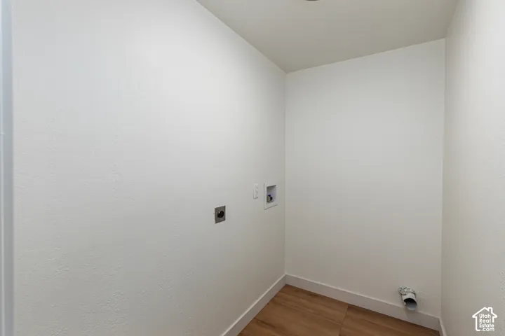 Laundry area with wood-finish flooring and recessed ceiling lighting