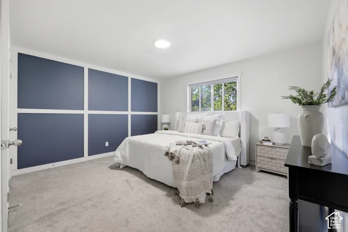 Accent wall with decorative trim, large window, overhead lighting, and soft carpet flooring