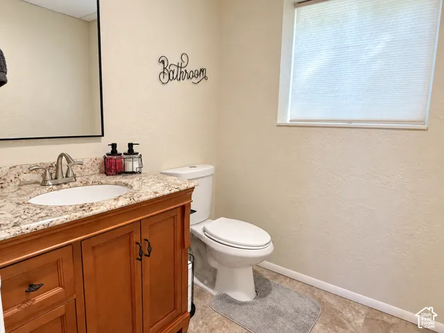 Wood-finish vanity with an integrated sink and stone countertop