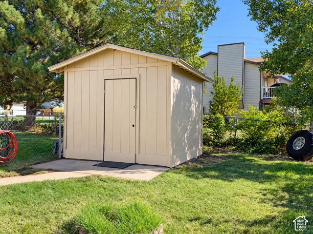 Exterior storage shed featuring a single entry door and a pitched roof