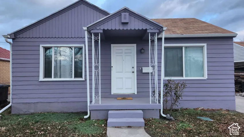 Purple siding exterior with white window frames and a white front door