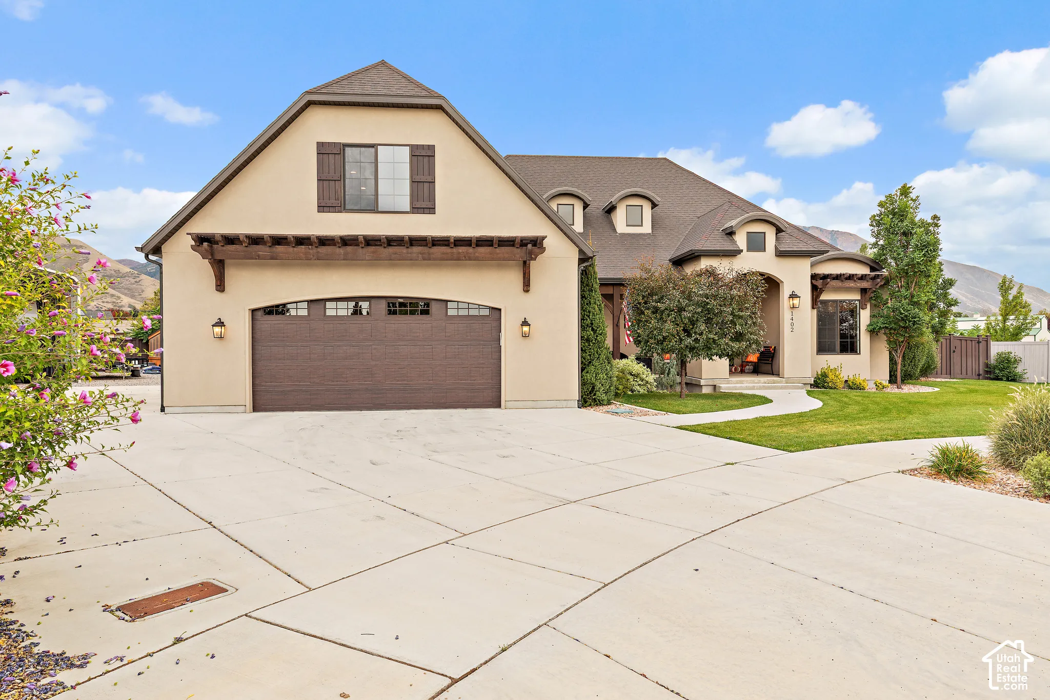 Stucco exterior with a dark brown hip roof and dormer windows