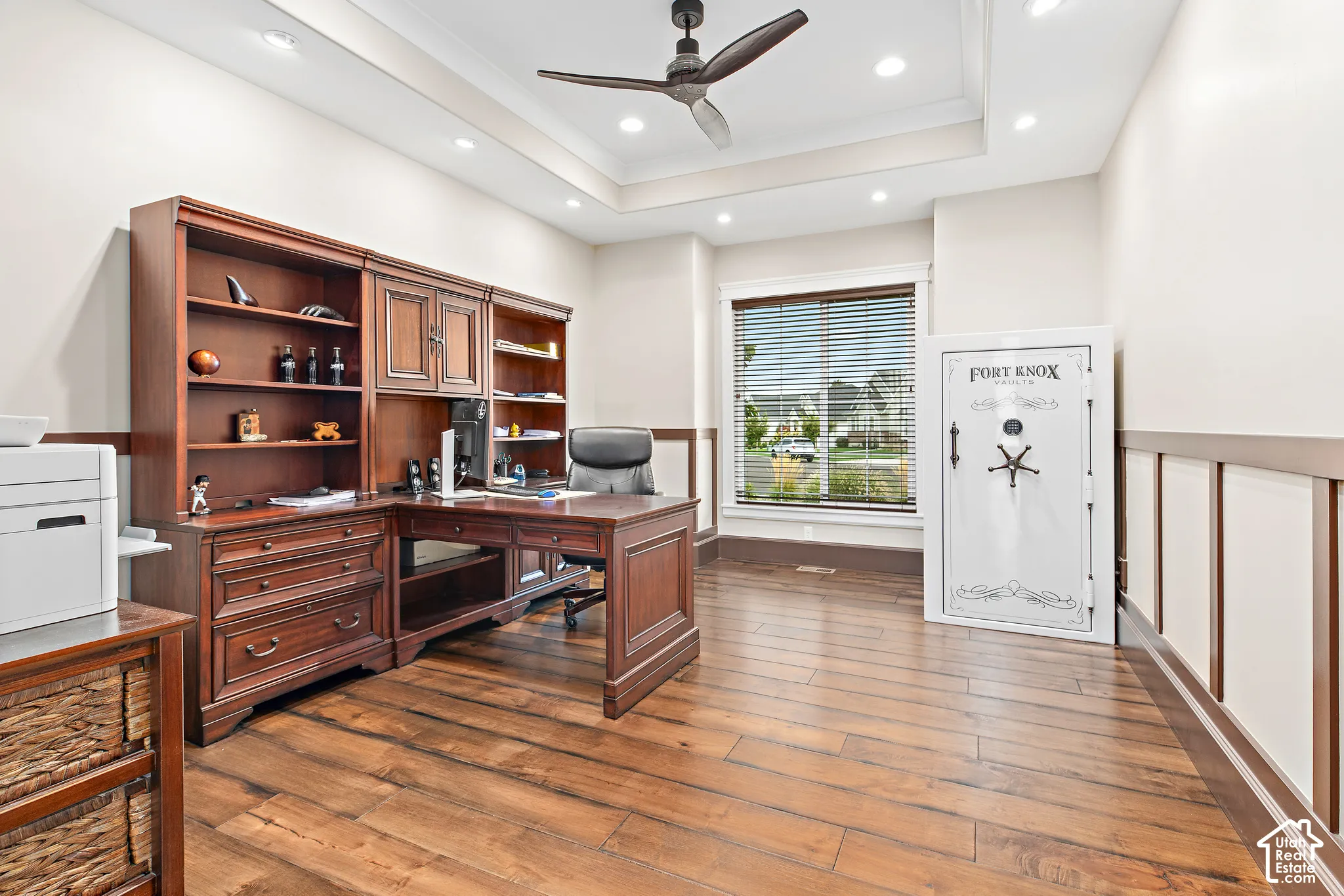 Wood-finish flooring with a tray ceiling and recessed lighting