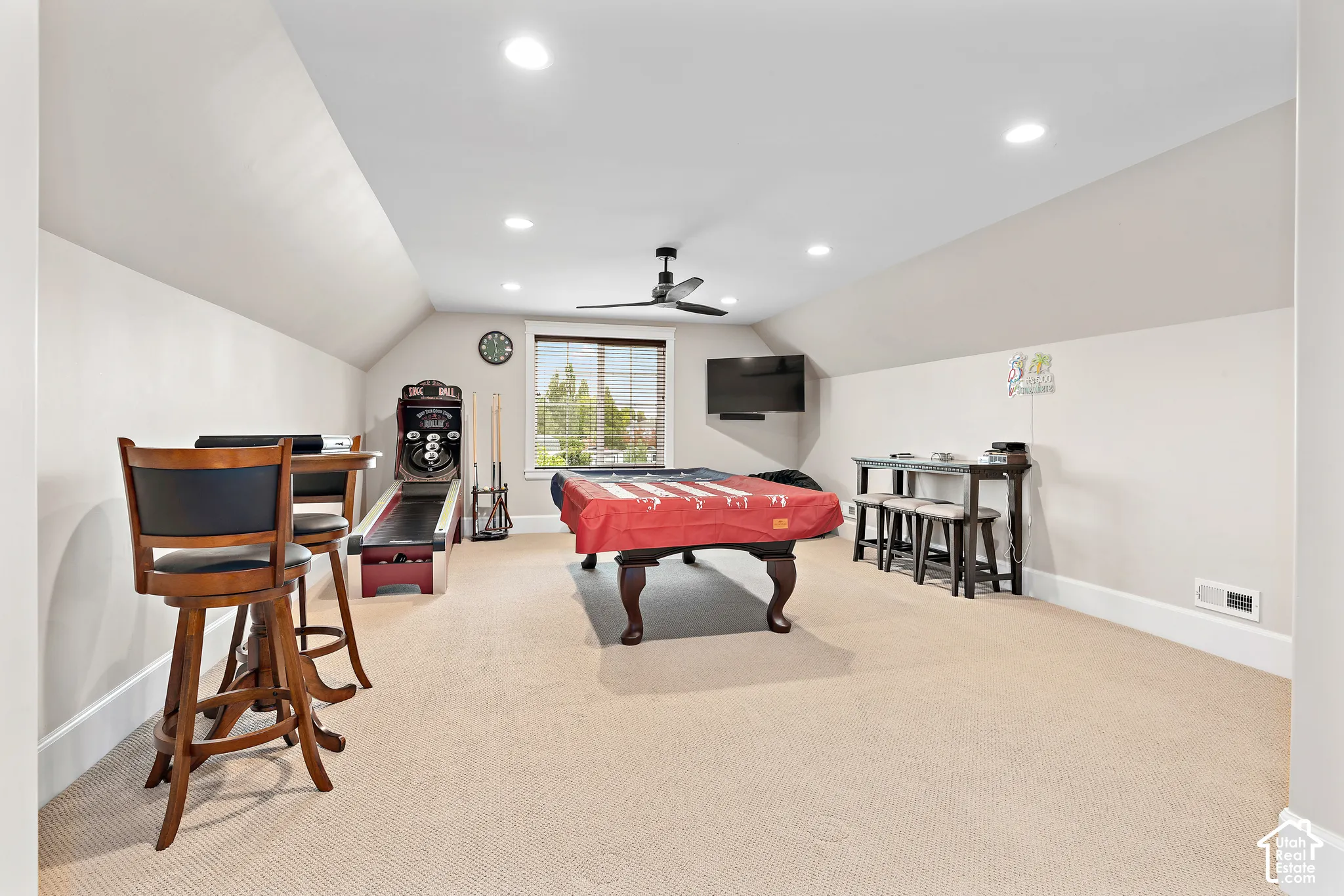 Spacious bonus room featuring vaulted ceilings, recessed lighting, carpet flooring, a ceiling fan, and a double window