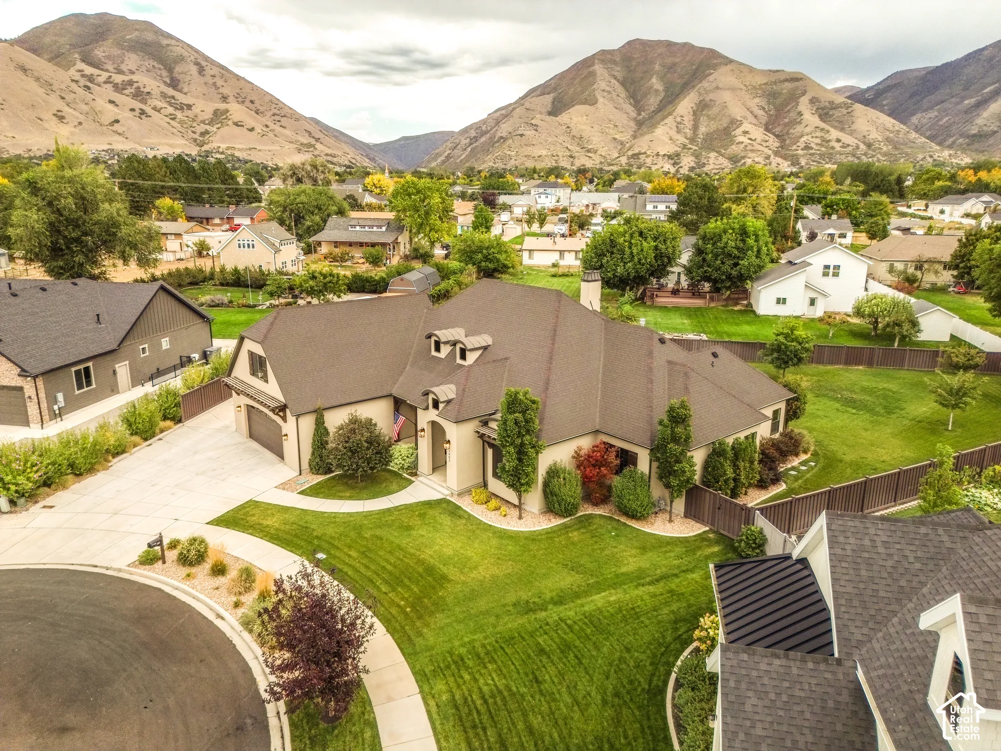 Expansive property featuring a multi-gabled roofline, concrete driveway, and a manicured lawn