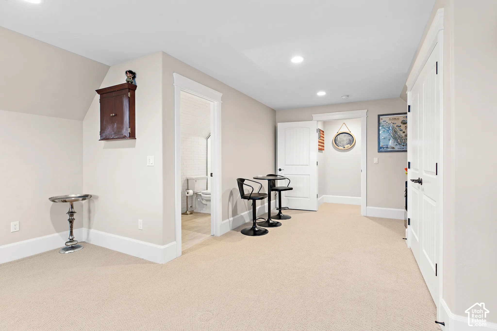 Recessed ceiling lighting, light-toned wall paint, white trim, white paneled doors, and light-toned carpeting