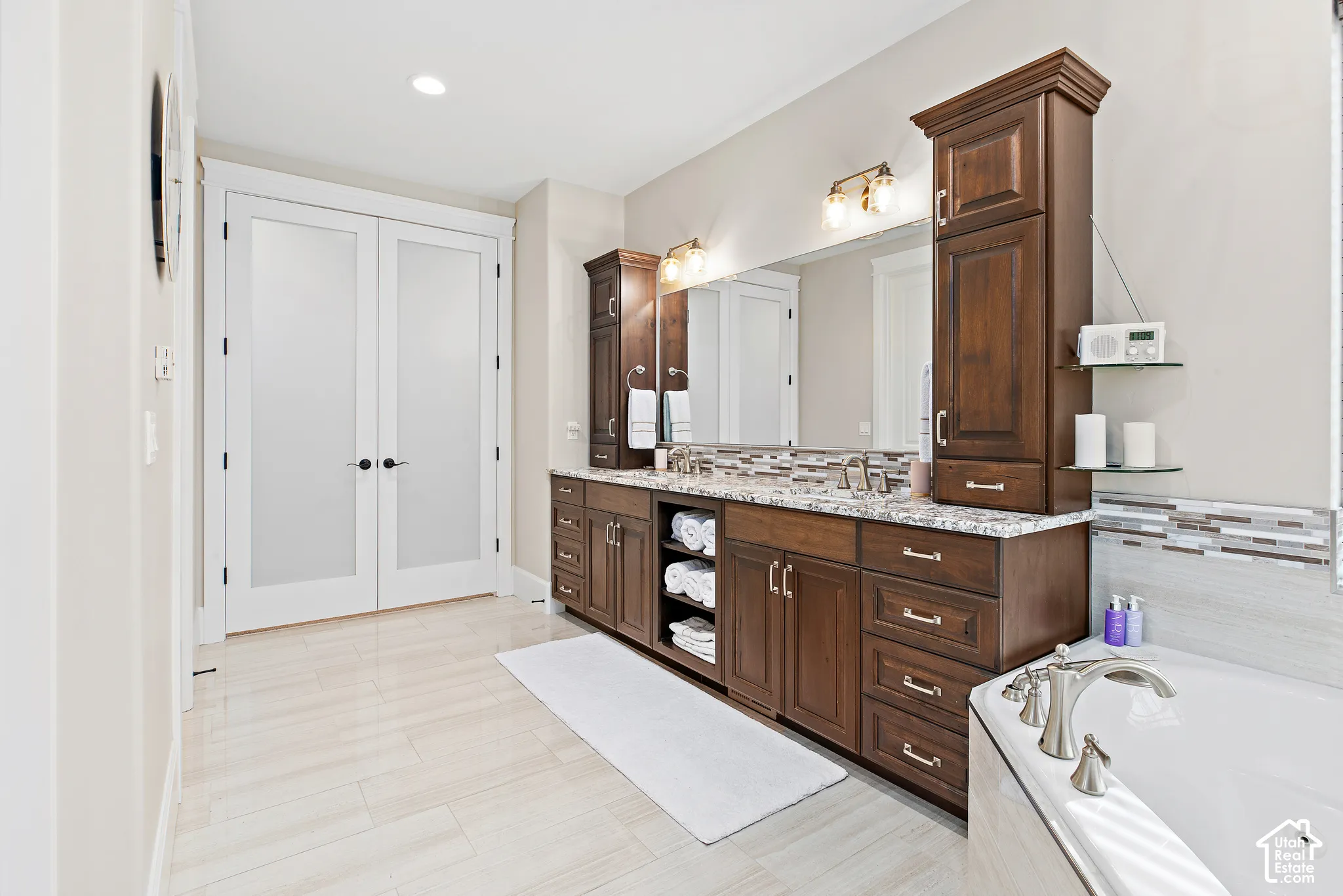 Dual vanity with wood cabinetry and granite-style countertop