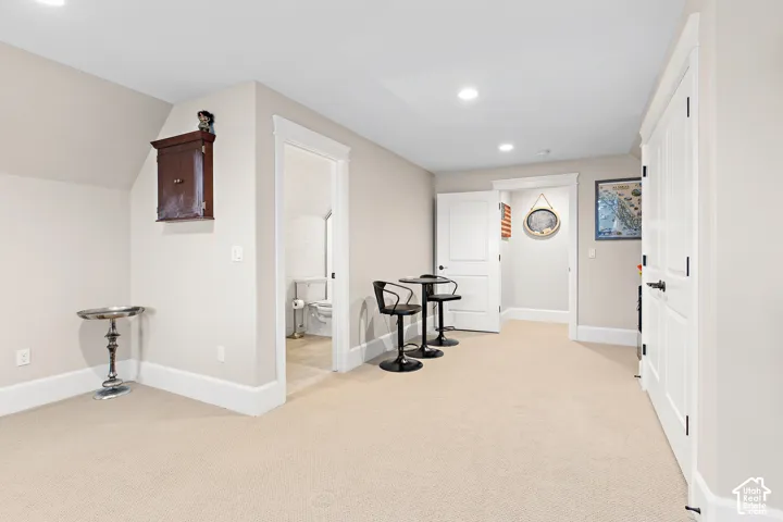 Recessed ceiling lighting, light-toned wall paint, white trim, white paneled doors, and light-toned carpeting
