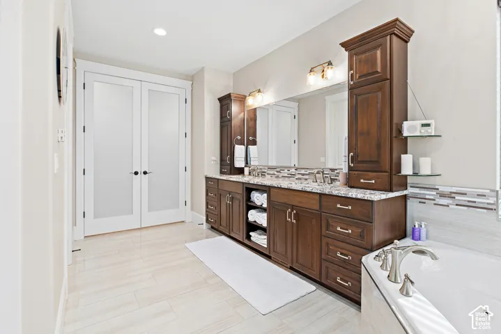 Dual vanity with wood cabinetry and granite-style countertop