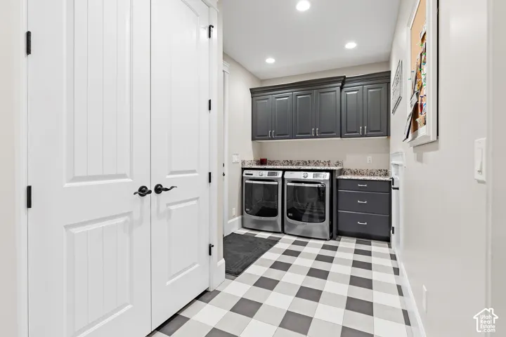 Checkered tile flooring with gray and white squares, dark gray cabinetry, stone-finish countertops, and recessed lighting