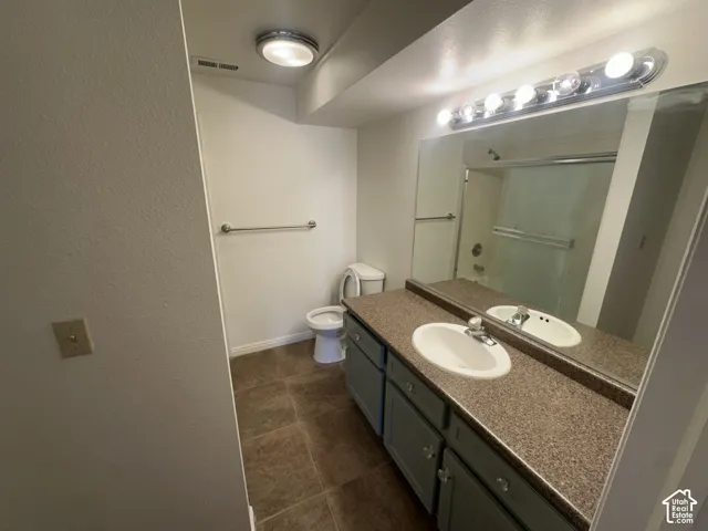 Vanity with dual integrated sinks, speckled countertop, and gray cabinetry