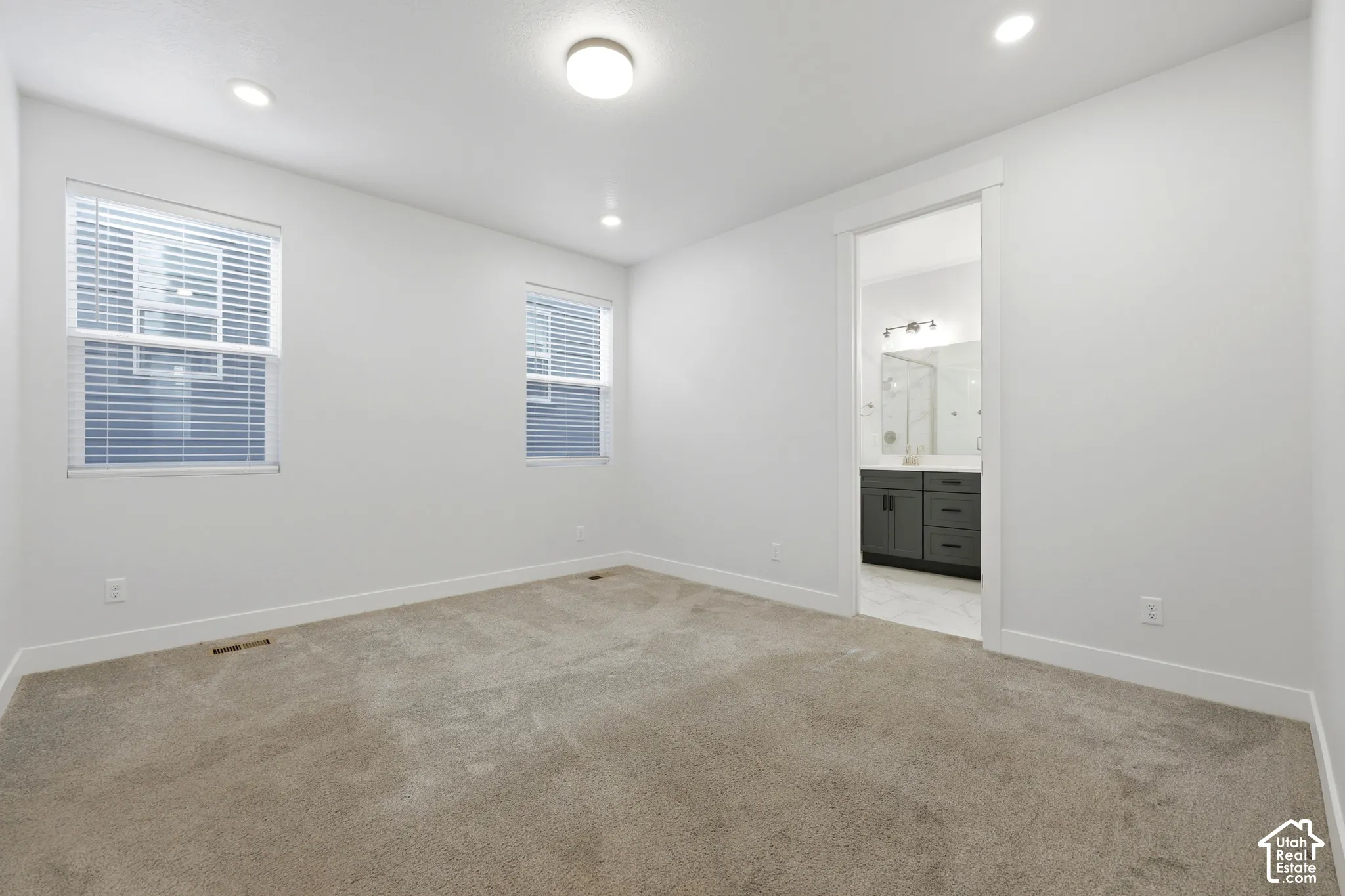 Neutral tone wall paint, recessed lighting, ceiling-mounted light fixture, and carpet flooring