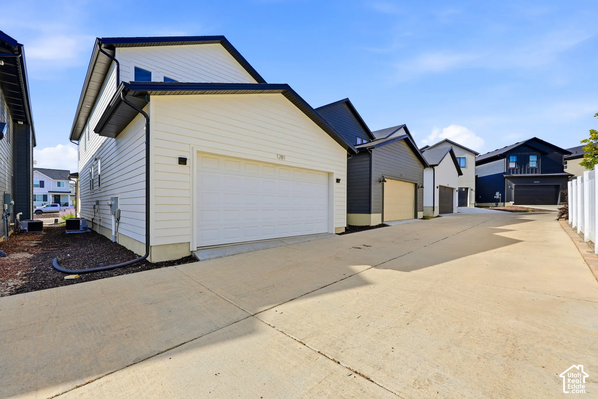 Modern exterior featuring white horizontal siding, a black roof, and an attached garage with a white door