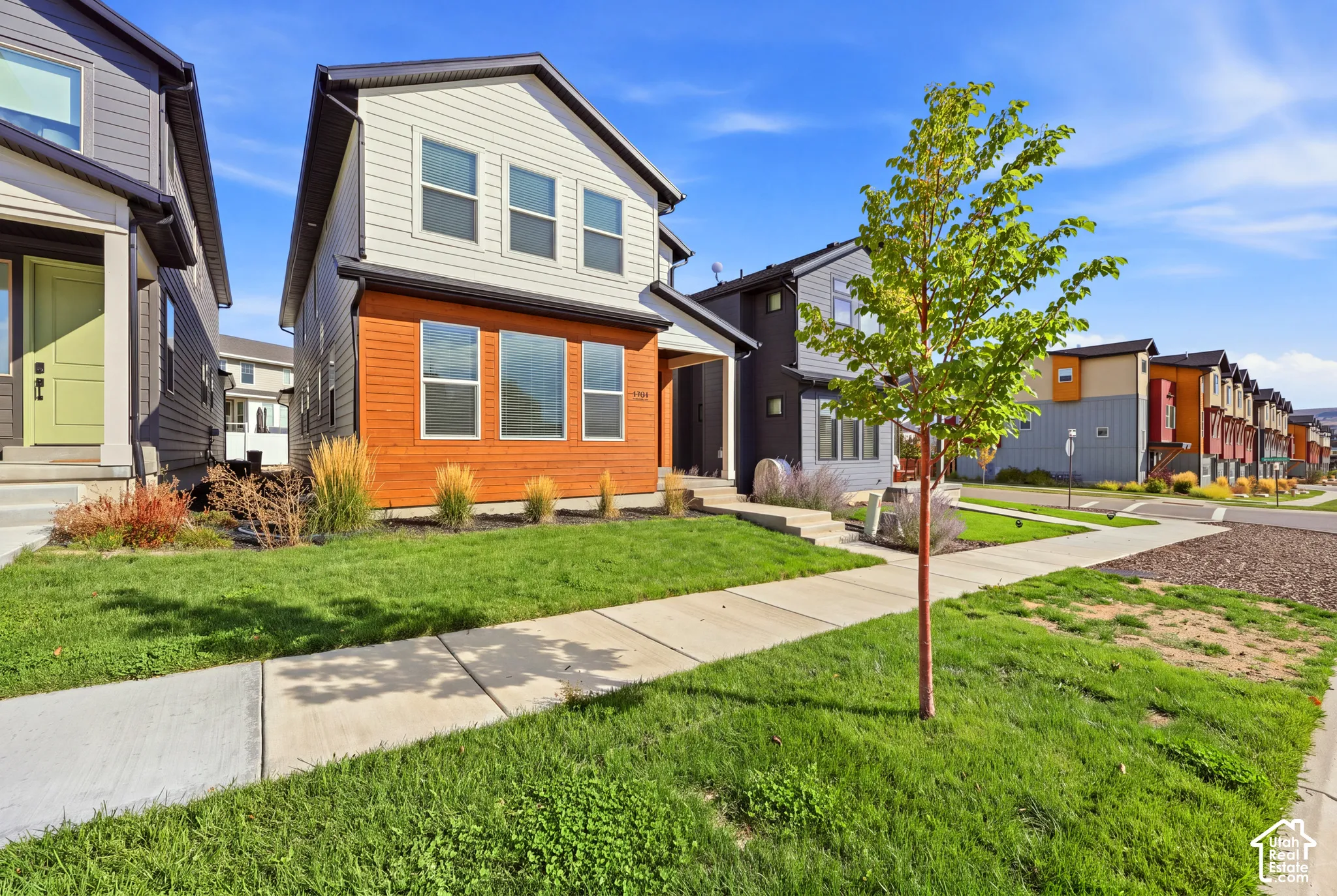Two-story exterior with light siding and wood-finish paneling