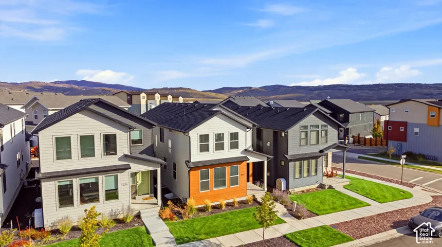 Contemporary-style homes featuring dark-shingle roofing, light-toned siding, and paved walkways