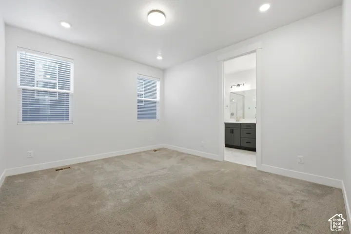 Neutral tone wall paint, recessed lighting, ceiling-mounted light fixture, and carpet flooring