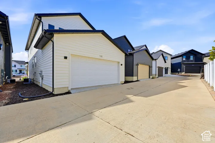 Modern exterior featuring white horizontal siding, a black roof, and an attached garage with a white door