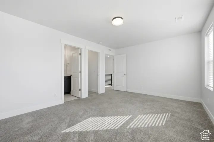 Recessed lighting, carpeted flooring, white interior doors, and a window with blinds