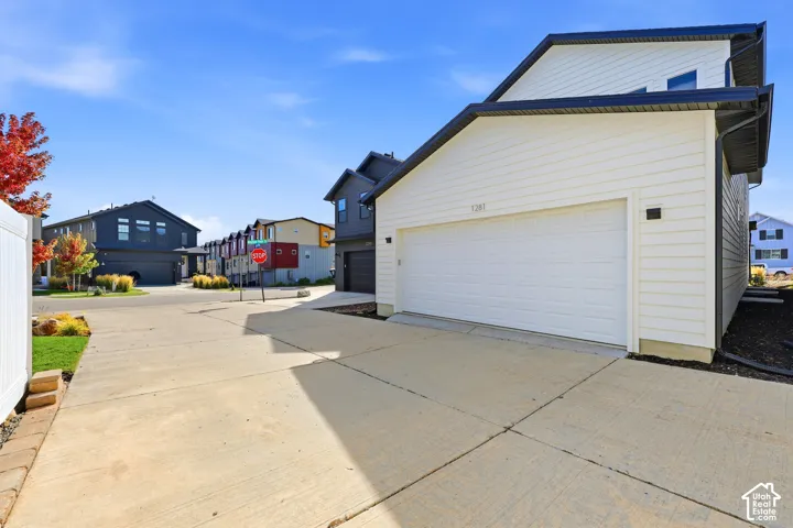 White siding exterior with black trim, concrete driveway, and attached garage