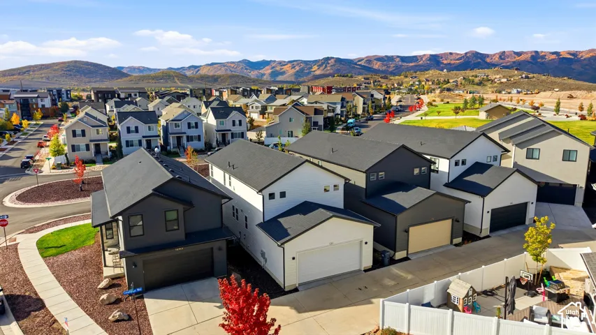 Modern residential architecture with varied exterior finishes, attached garages, and a paved driveway