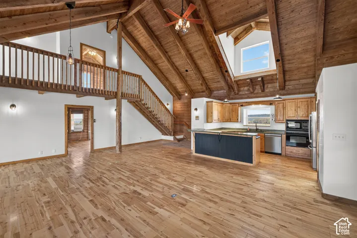 Open-concept great room with soaring vaulted ceilings and exposed wood beam architecture