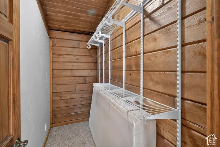Angled wood-paneled wall with white wire shelving system