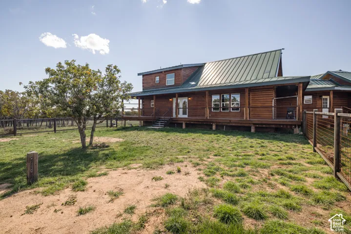 Wood-sided residence featuring a metal roof and an expansive covered porch