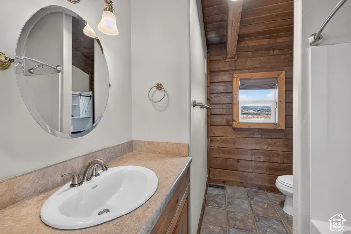 Vanity with an integrated oval sink, wood-finish cabinetry, and a countertop