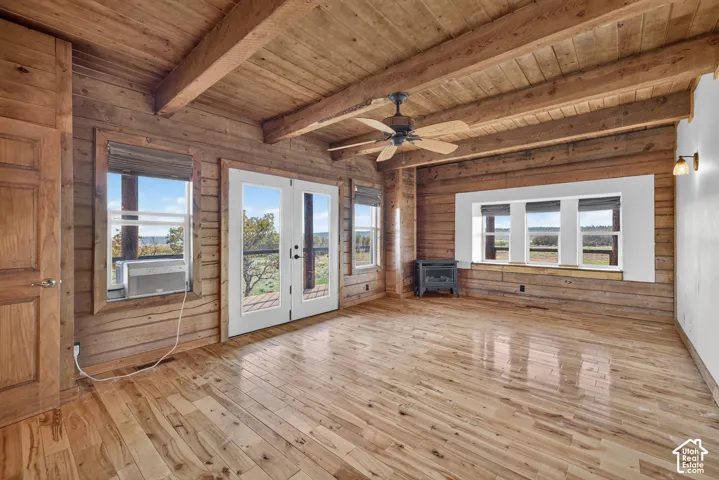 Wood-finish flooring with an exposed beam ceiling, complemented by wood-paneled walls