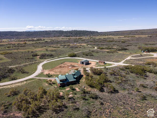 Expansive property with a central residence, outbuildings, and winding pathways